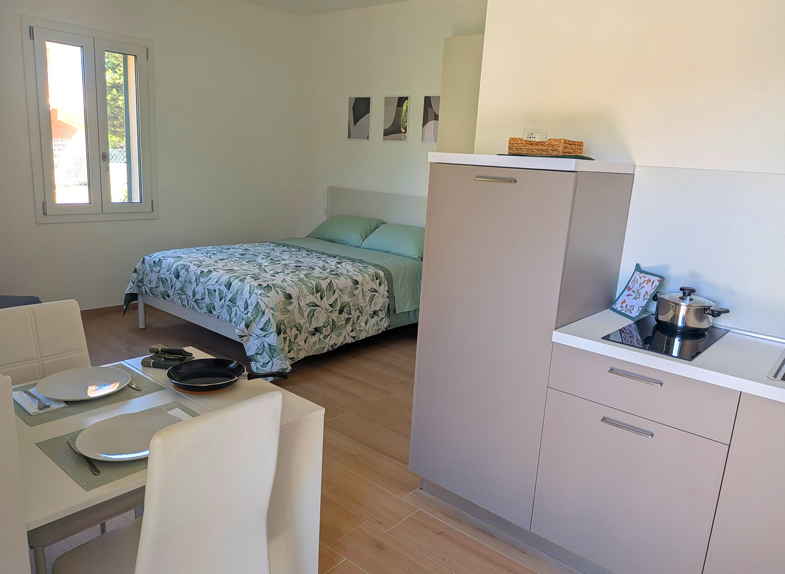 Interno del monolocale Aria di Capanna Deluxe a Teramo con cucina, zona pranzo e letto matrimoniale